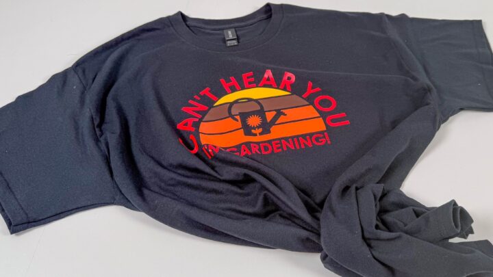 Close-up of handmade retro gardening shirt featuring layered sunset design with text curved above and below.